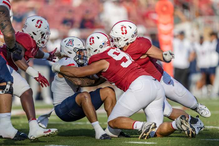 Sep 23, 2023; Stanford, California, USA; Arizona Wildcats quarterback Jayden de Laura (7) is sacked by Stanford Cardinal defensive lineman Zach Buckey (98) during the second quarter at Stanford Stadium. Mandatory Credit: John Hefti-USA TODAY Sports